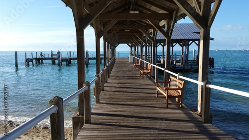 Covered Wood Pier Dock On The Ocean Water On The Horizon photo