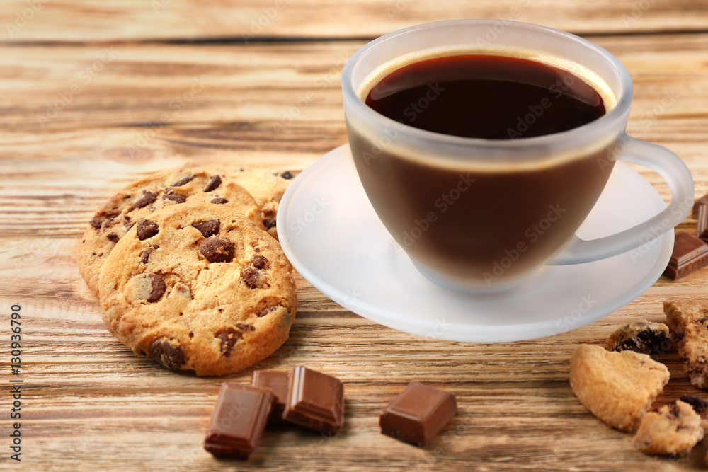Tasty chocolate cookies with cup of hot coffee on wooden background Tasty chocolate cookies with cup of hot coffee on wooden background