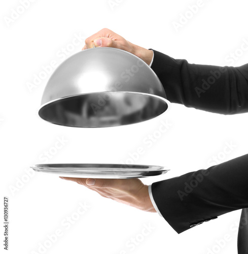 Hands of waiter holding metal tray with cover on white background photo