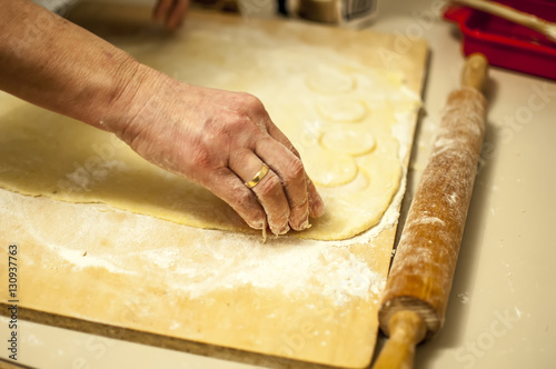 preparare i biscotti di natale con farina uova zucchero e marmellata con il mattarello photo