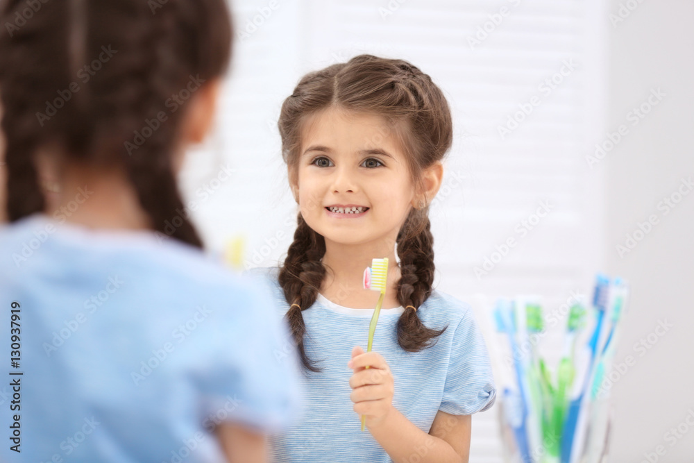Funny little girl brushing teeth in bathroom Funny little girl brushing teeth in bathroom