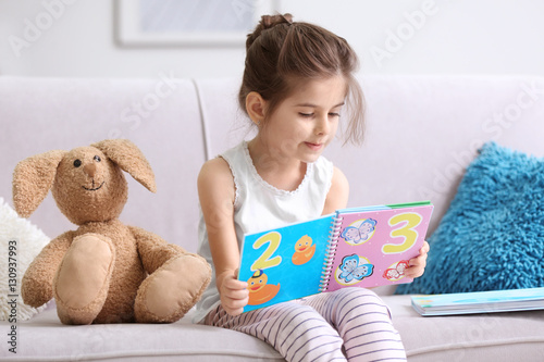 Funny little girl reading b...