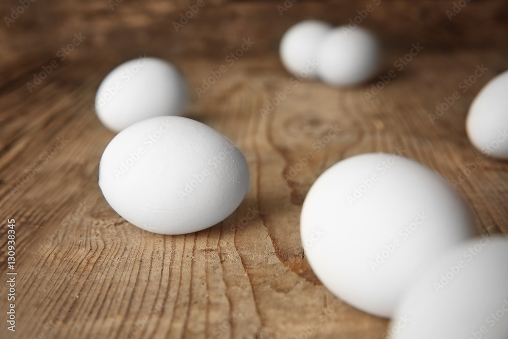 Raw eggs on wooden board, closeup Raw eggs on wooden board, closeup