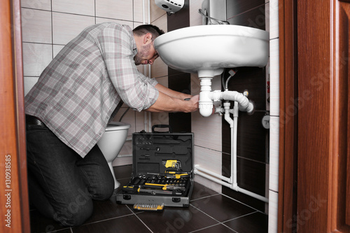 Plumber repairing sink pipe...