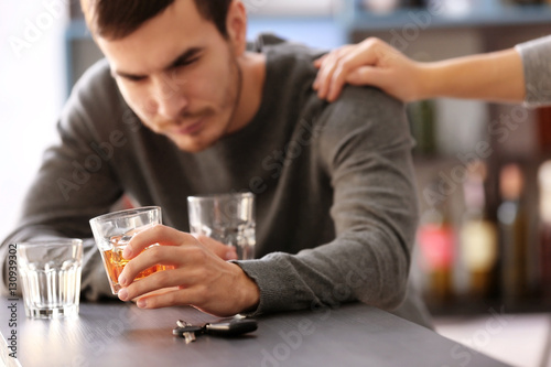 Man with car key and alcoholic beverage in bar. Don t drink and drive concept