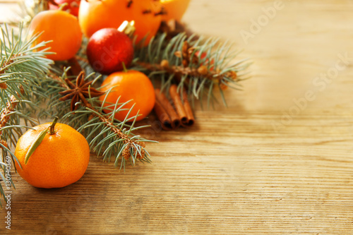 Composition of citruses, spices and coniferous branches on wooden background