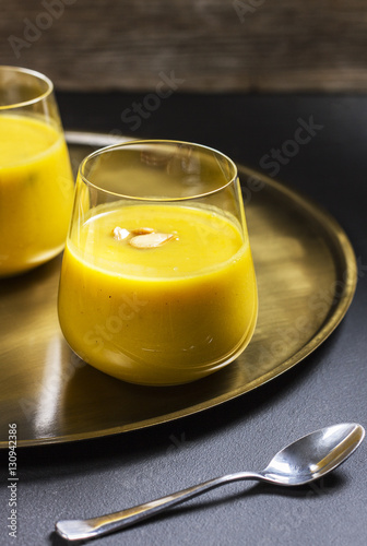pumpkin soup in a glass on a golden plate