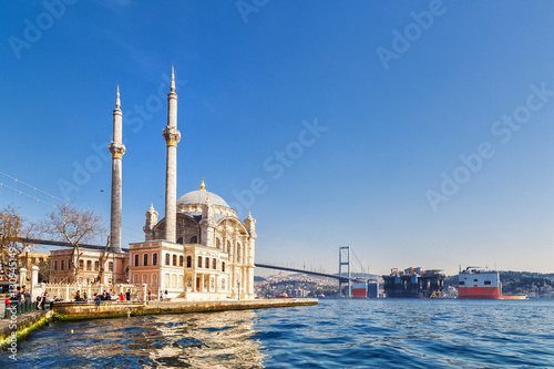 Fototapeta ISTANBUL, TURKEY: Tourists admiring the view of the Otrakoy Mosque in Istanbul,