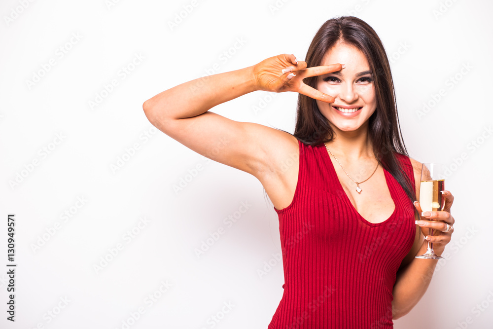 Pretty young woman in red dress drinking champagne over white background Pretty young woman in red dress drinking champagne over white background