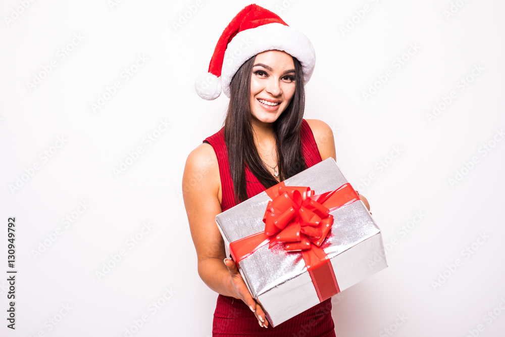 Young woman in red dress with santa hat hold Christmas gift over white background Young woman in red dress with santa hat hold Christmas gift over white background