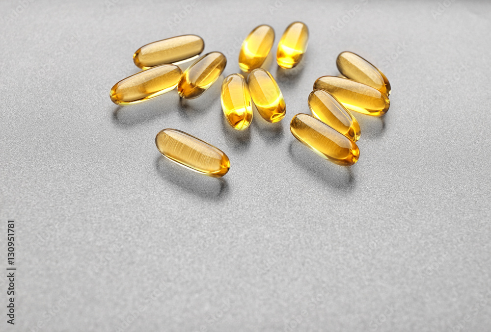 Fish oil capsules on grey background Fish oil capsules on grey background