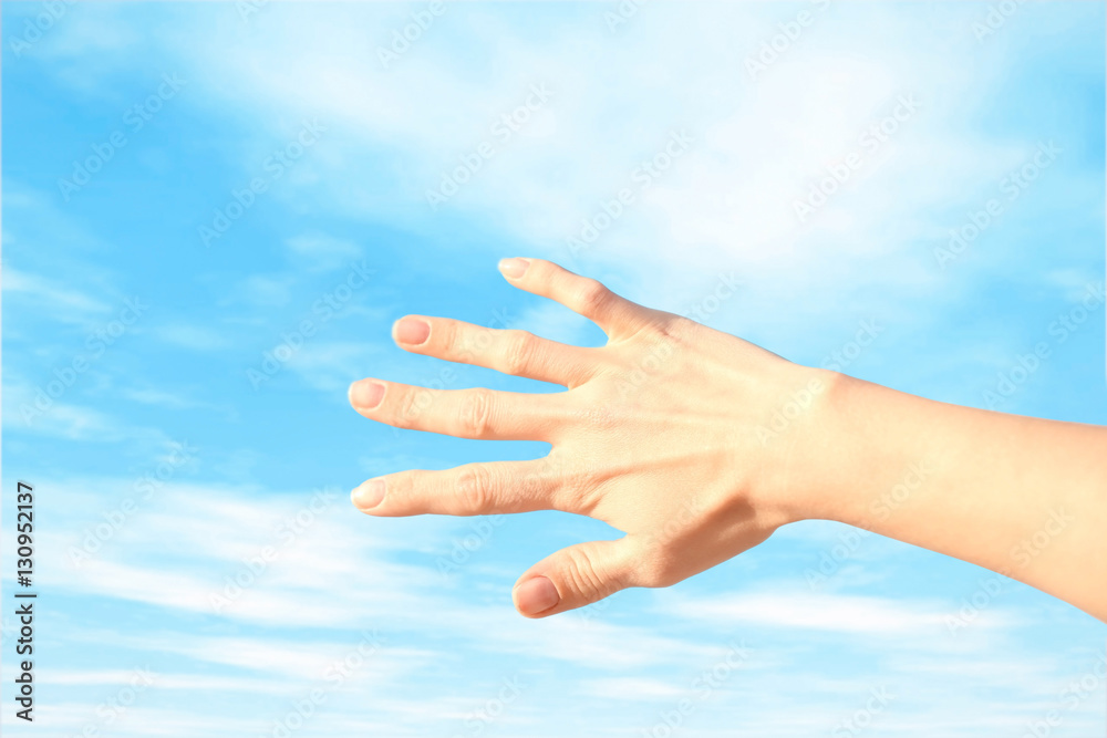 Female hand on sky background