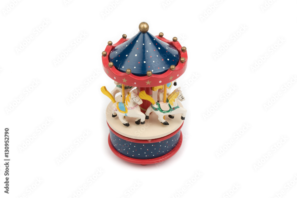 Fototapeta premium Musical carousel with horses. Blue, red, white merry go round. Toy. Vintage carousel, made from solid wood. Winter, Christmas, New Year decoration. Isolated on white background. Closeup. 