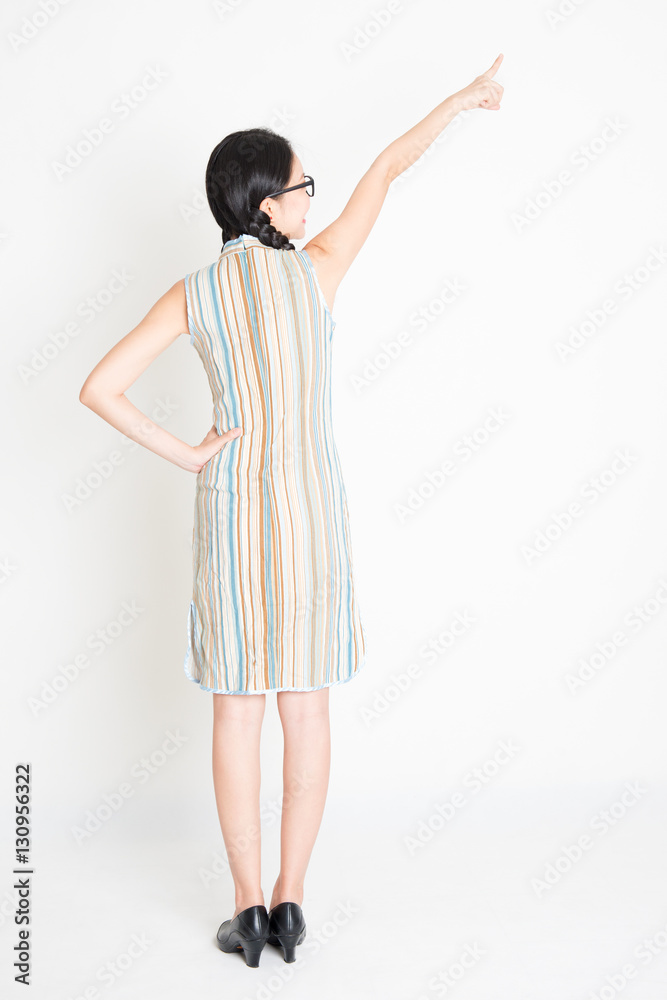 Rear view Asian girl pointing away Rear view Asian girl pointing away