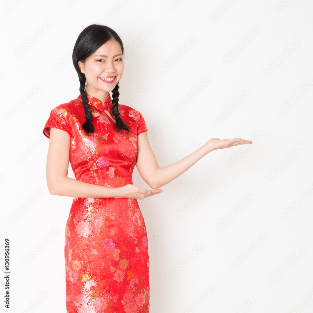 Oriental girl in red qipao hand showing something Oriental girl in red qipao hand showing something