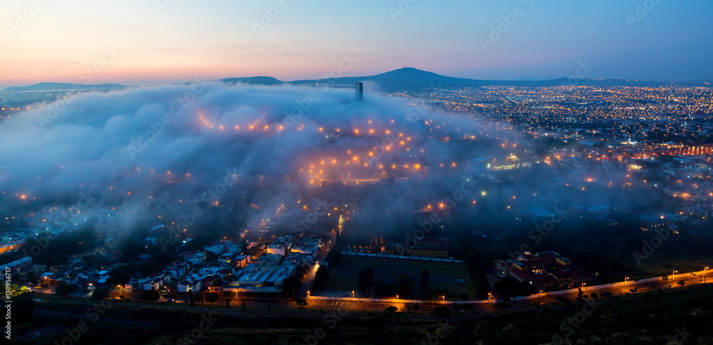 Early morning fog over the rising city of Queretaro Mexico. The aqueduct of Queretaro, is currently building a monumental seventy four arches reaching an average height of twenty eight meters. 