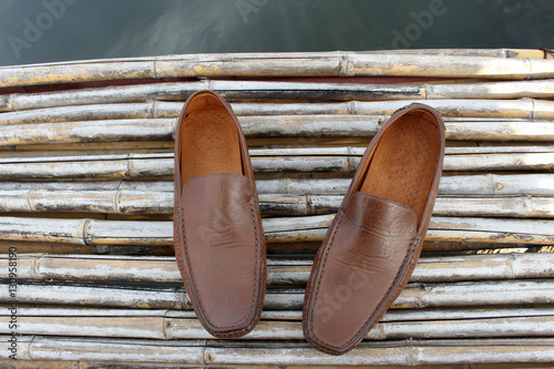 Brown shoe on bamboo wood over pond