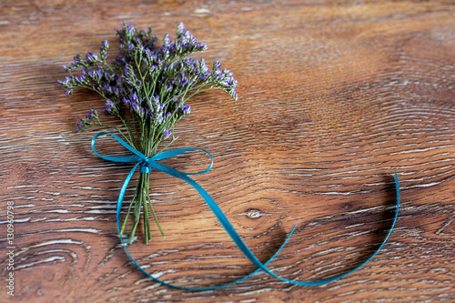 Delicate bouquet of flowers and a wooden abstract background. Limonium.