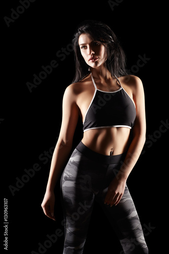 Portrait of a young brunette sporty fitness woman on black © Serg Zastavkin