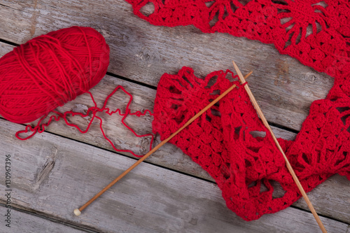 Red knitting and wooden knitting needles.