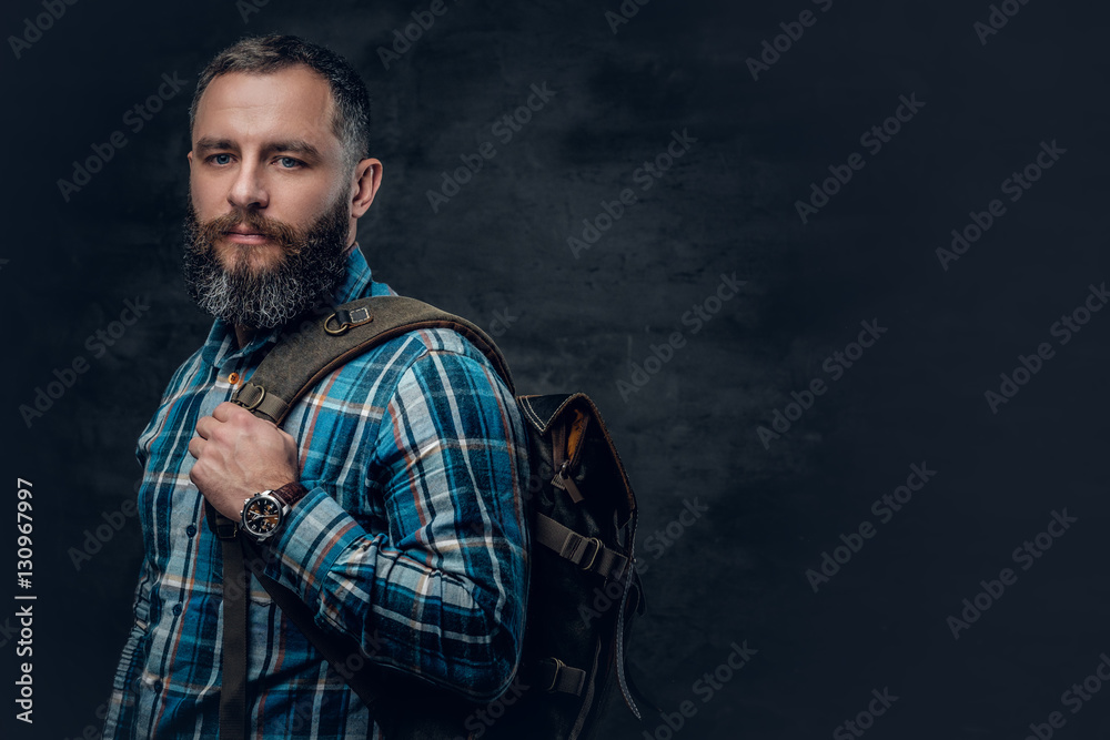 Middle age male holds backpack on a shoulder.