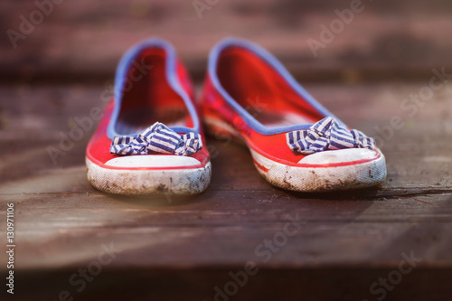 pair of red women's ballet shoes on a wooden background.