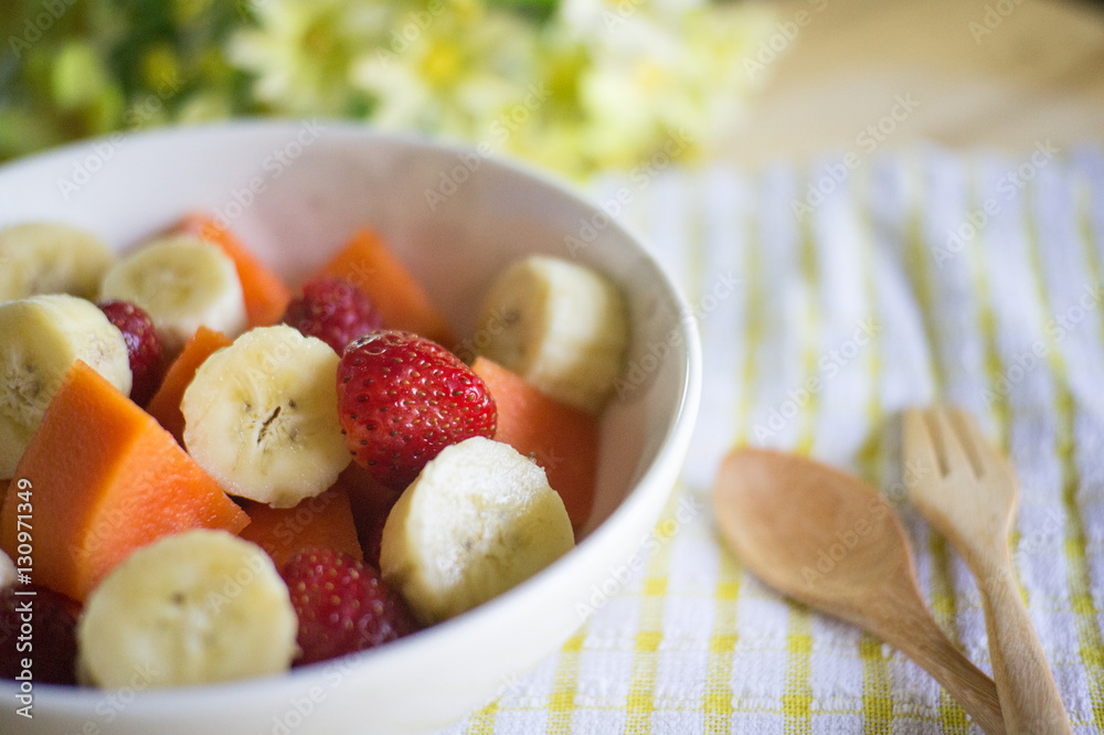 fruits salad on Wooden Background. Fork and Spoon