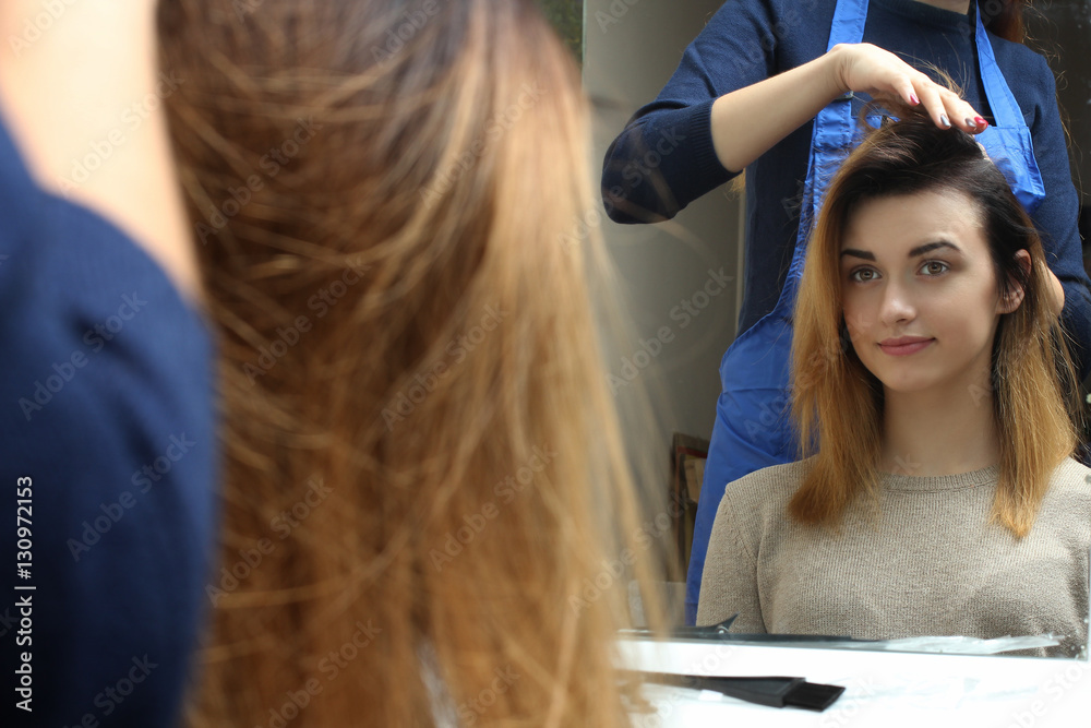 Fototapeta premium Closeup hairdresser coiffeur makes hairstyle.