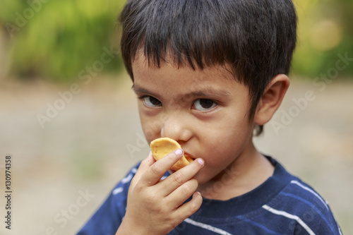 Asian little boy eating crisp rice