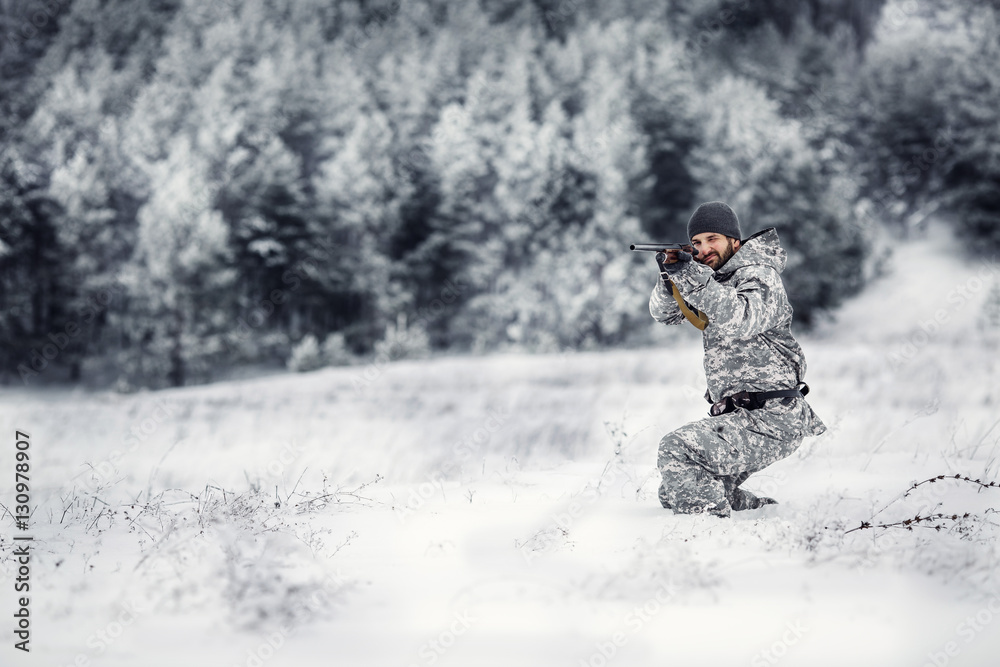 Male hunter in camouflage looking for his target or prey .Winter Male hunter in camouflage looking for his target or prey .Winter