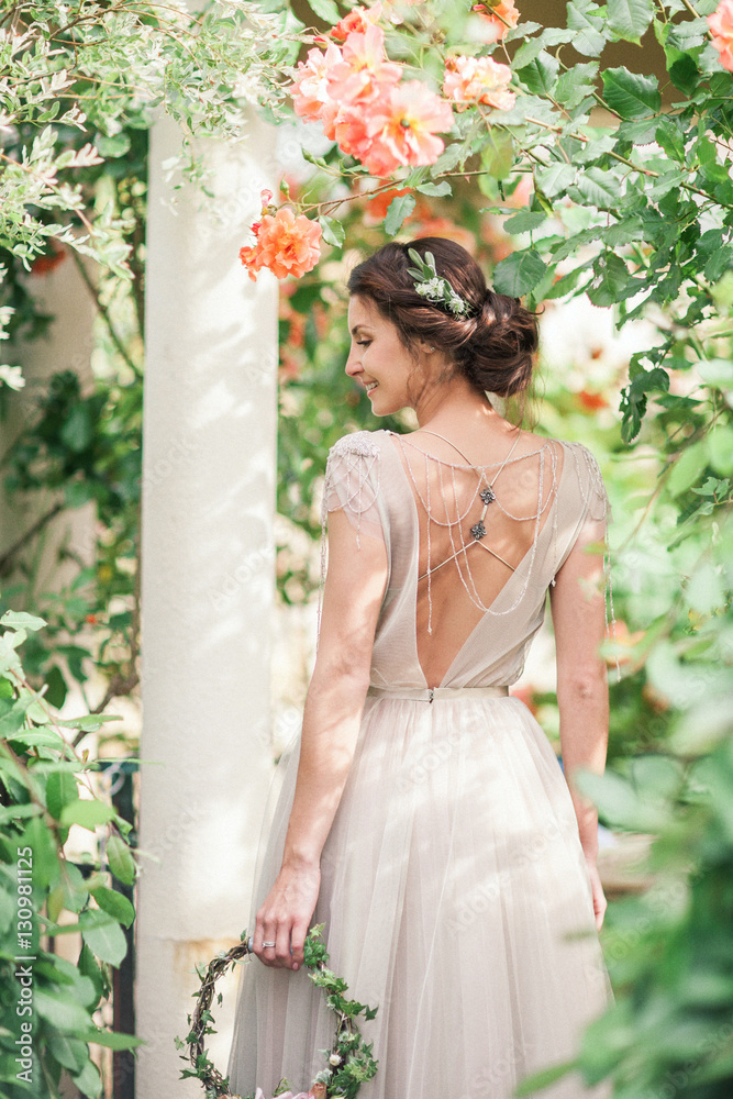 Bride in a beautiful dress with a bouquet of flowers and greener