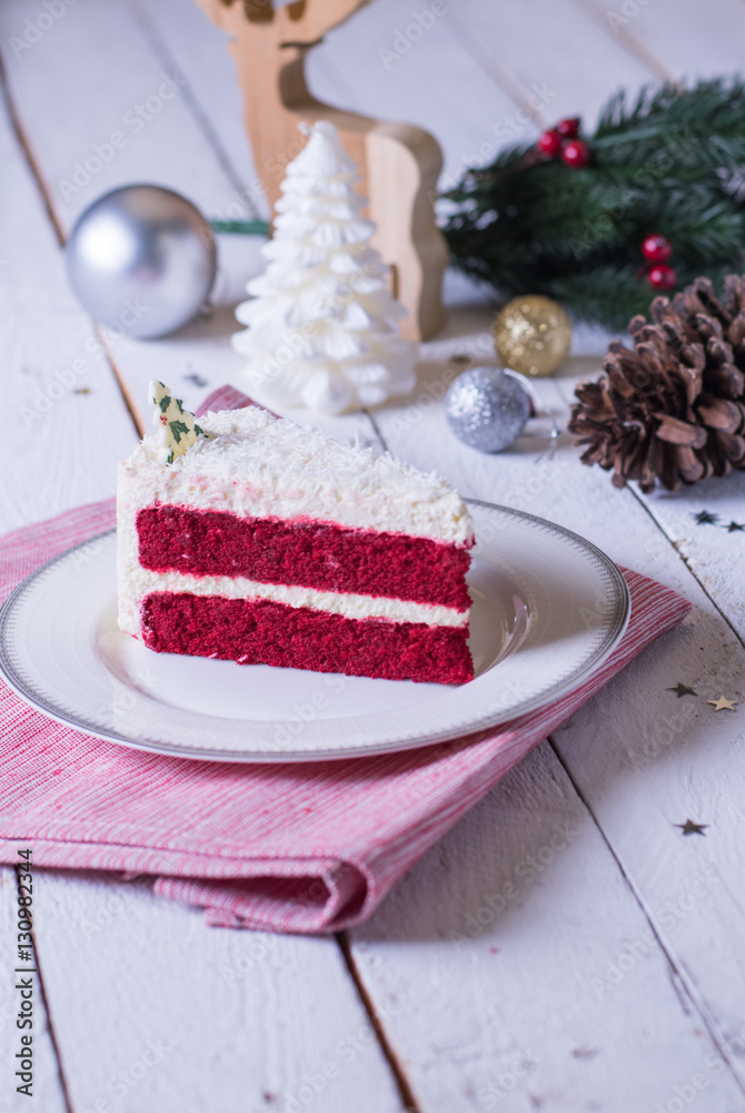 Christmas cake on plate on red fabric on wood background and dec Christmas cake on plate on red fabric on wood background and dec