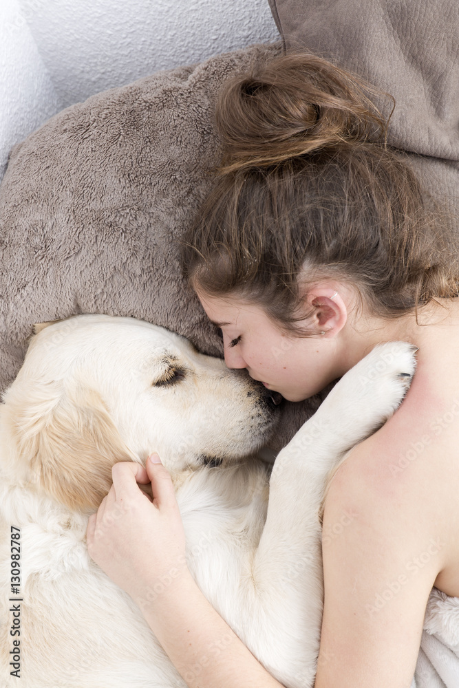 Teenage girl sleeping with her dog next to. Vertical shot with swab light from studio flax. Teenage girl sleeping with her dog next to. Vertical shot with swab light from studio flax.