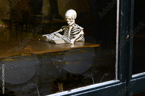 Skeleton reading book in the library