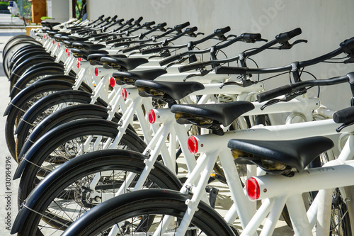 Bicycles stand in a row on a parking for rental