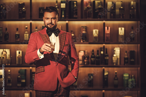 Extravagant stylish man with whisky glass in gentleman club photo