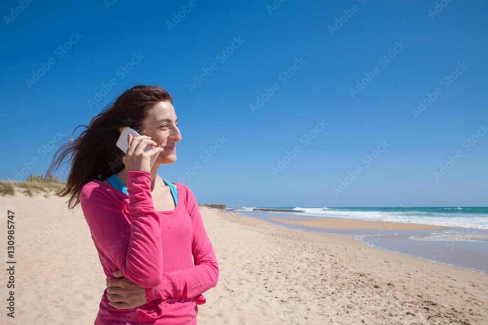 portrait of brunette woman looking side with pink sweater smiling and talking on mobile phone smartphone at beach with sea and blue sky behind
portrait of brunette woman looking side with pink sweater smiling and talking on mobile phone smartphone at beach with sea and blue sky behind