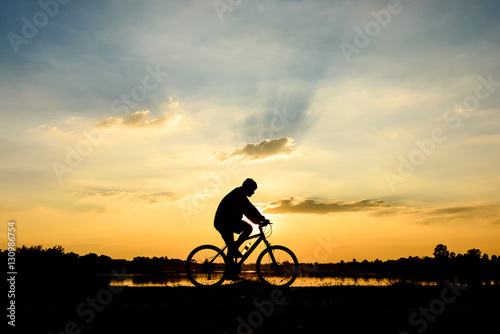 Silhouette of cyclist motion on sunset background © songdech17
