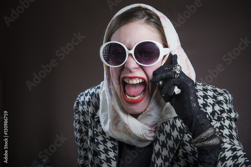 Vintage retro woman shouting over her telephone, angry with coustomer service photo