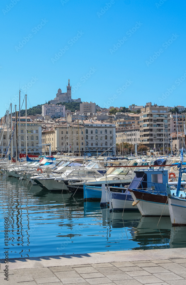 Yachts in the port of Marseilles on the background of the church of Notre Dame de la Garde
