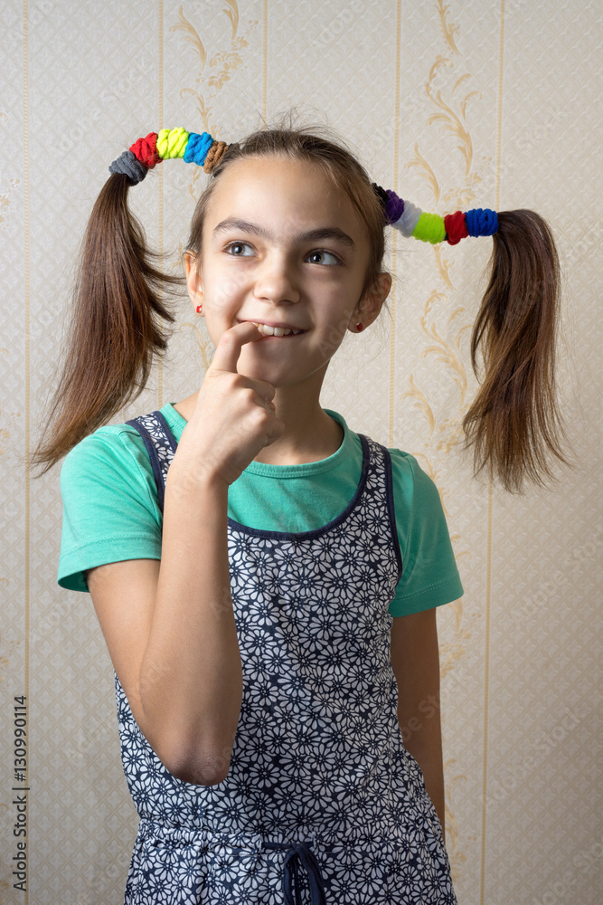 Φωτογραφία 11 year old girl with pigtails like Pippi Longstocking with a mischievous look on her face and her finger to her mouth thoughtfully looking up