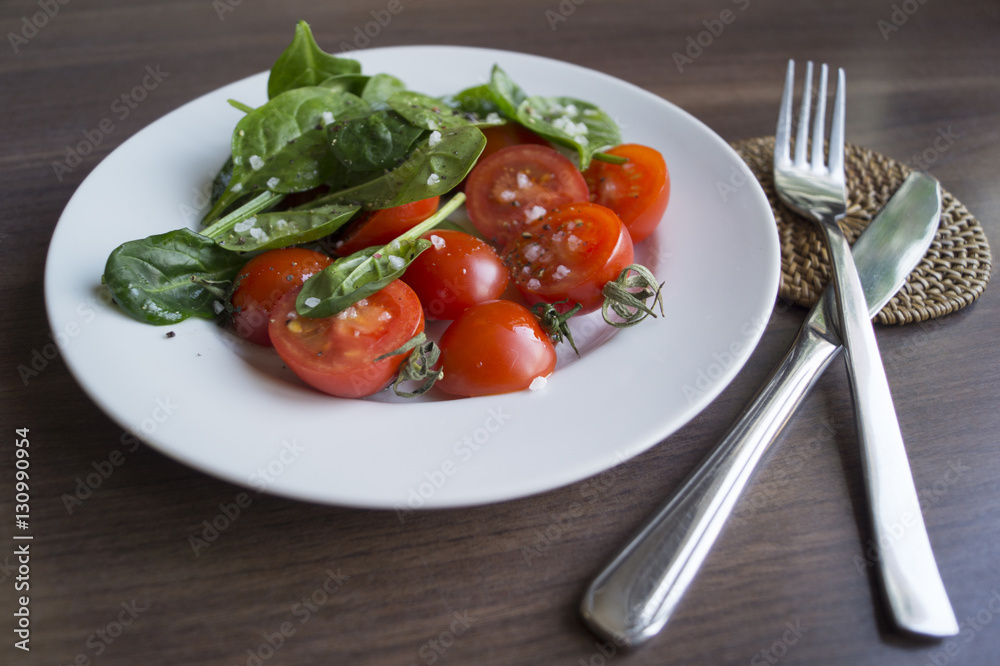 Salad of spinach and tomatoes with salt and olive oil Salad of spinach and tomatoes with salt and olive oil