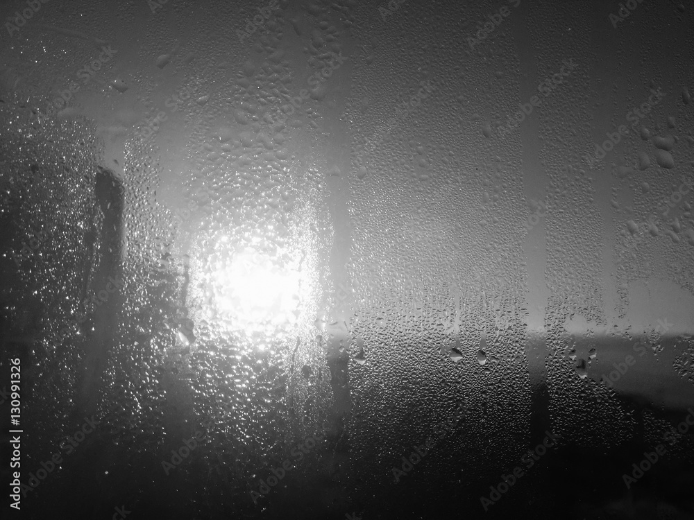 Obraz premium Raindrops on glass surface. Natural Pattern of rain drops window background in black and white.