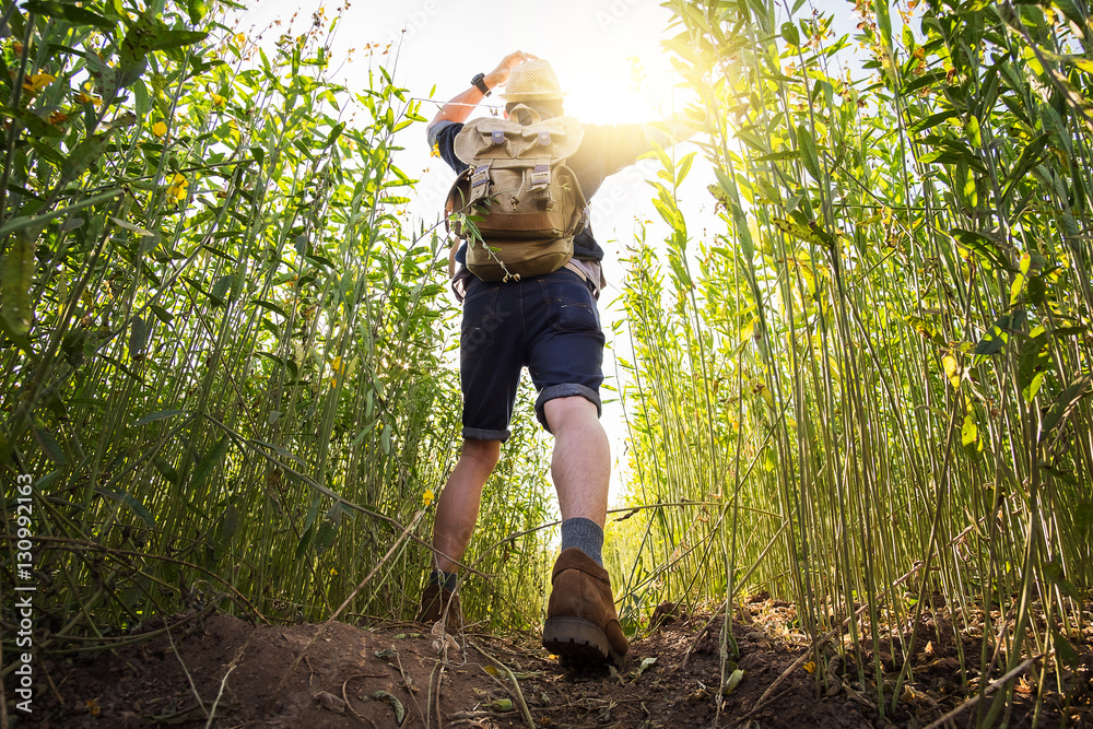 Young Man Traveler with backpack relaxing outdoor with rocky mou