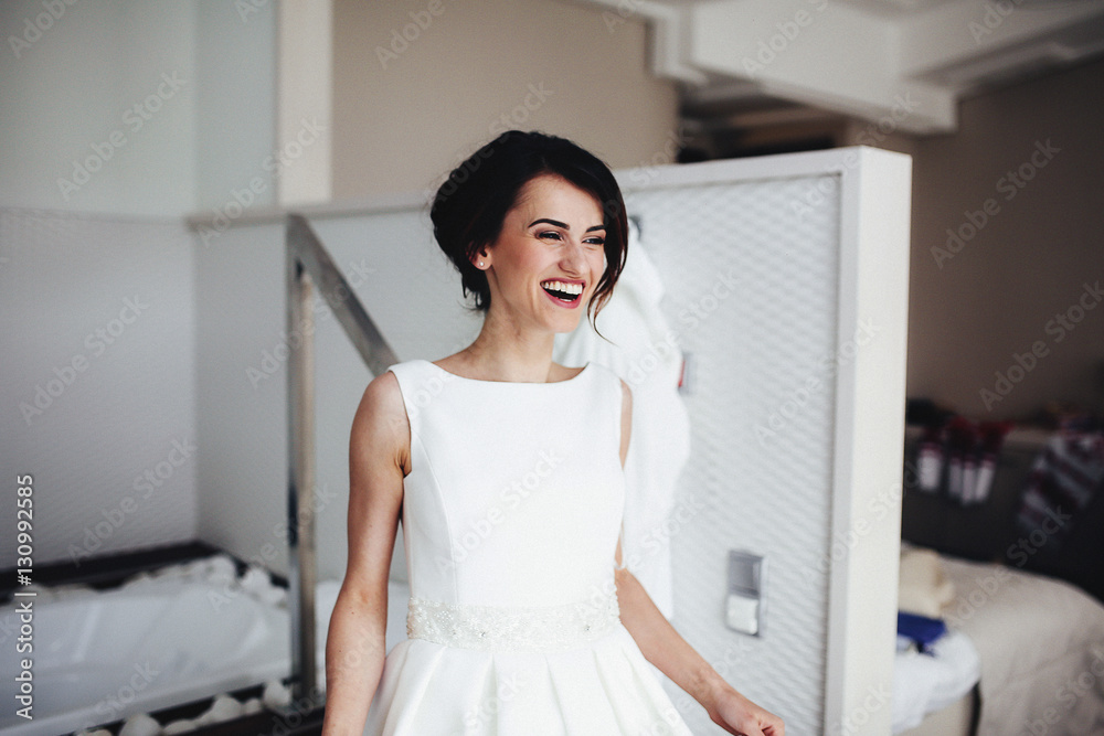 The smilling bride stands in the center of room The smilling bride stands in the center of room