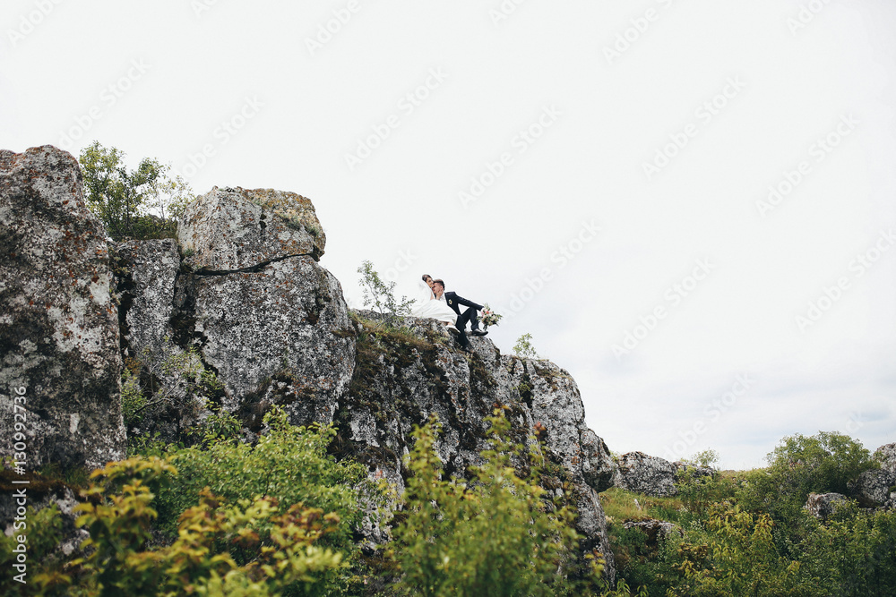The charming brides sitting on the stones