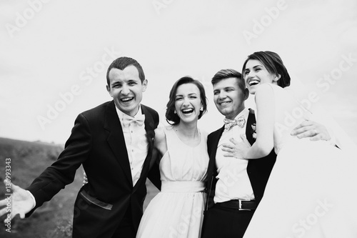 The brides and friends embracing on the stones