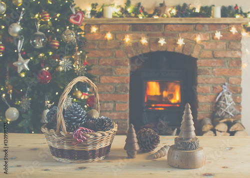 Diy Christmas: wooden toys, felt decorations, presents on the tables, Christmas tree and fireplace on the background, selective focus photo