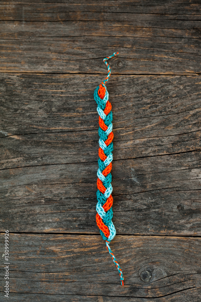 Ταπετσαρία Handmade knitted bracelet on a wooden background