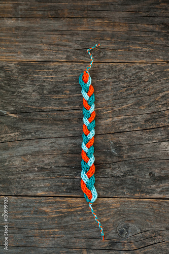 Fotografi Handmade knitted bracelet on a wooden background